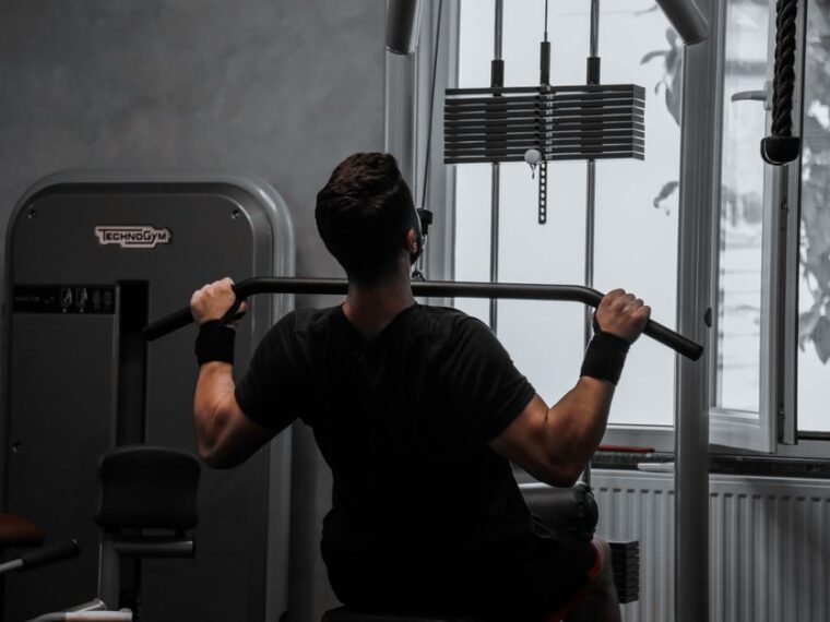 Sportif réalisant un tirage vertical à la poulie haute pour le dos