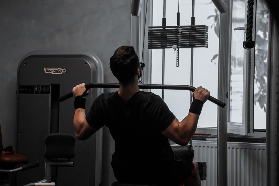 Sportif réalisant un tirage vertical à la poulie haute pour le dos
