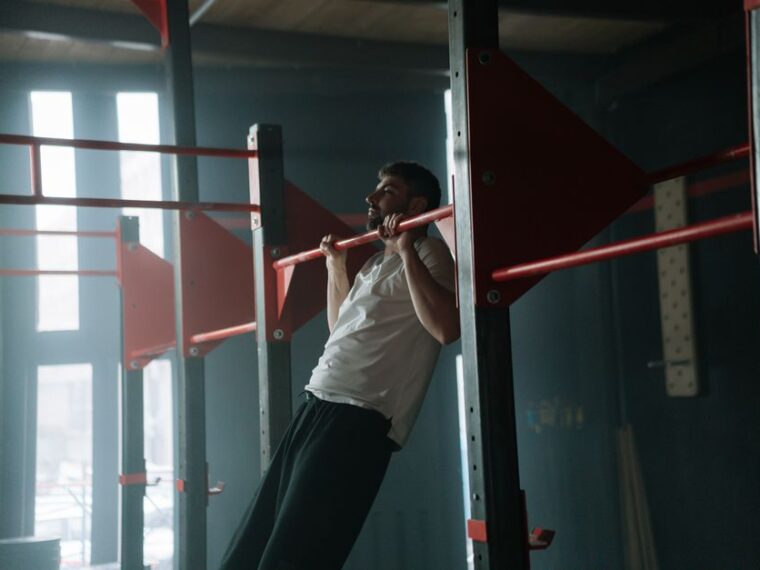 Pratiquant effectuant un muscle up à la barre